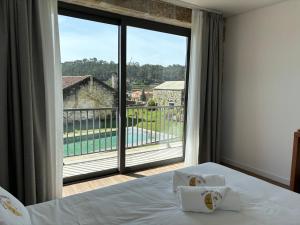 una camera con un letto e una grande finestra di Paços do Douro, Chambre privée avec piscine a Romariz