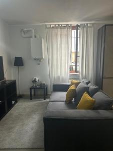 uma sala de estar com um sofá com almofadas amarelas em modern apartment Legnano em Legnano