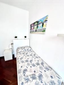 a bed in a room with a white wall at CASA ELENA- Casa Vacanze nel centro di Sottomarina in Chioggia