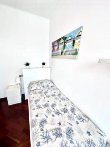 a bed in a room with a white wall at Da Elsa in Chioggia