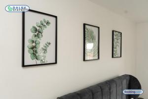 a living room with three framed plants on a wall at Lovely 3 bed Home for contractors, families, groups - Gated parking in Manchester