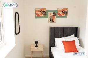 a bedroom with a bed and some pictures on the wall at Lovely 3 bed Home for contractors, families, groups - Gated parking in Manchester