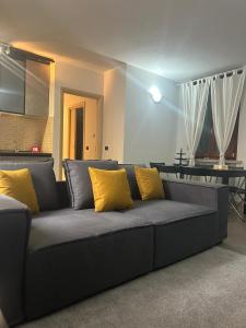 um sofá com almofadas amarelas numa sala de estar em modern apartment Legnano em Legnano