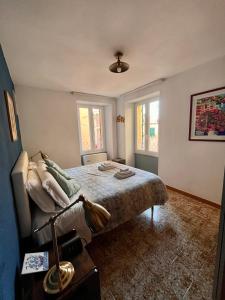 um quarto com uma cama e duas janelas em RioRooms La Valletta Riomaggiore Center em Riomaggiore