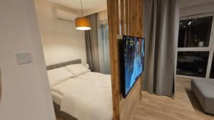 a room with a bed and a flat screen tv at Vision Apartments Gdańsk in Gdańsk