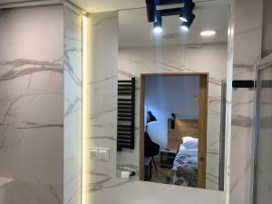 a mirror in front of a room with a bed at Apartament Kalina - Wyszyńskiego in Świeradów-Zdrój