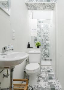 une salle de bains blanche avec toilettes et lavabo dans l'établissement Host Wise - Spacious Sunny House with terrace & BBQ, à Vila Nova de Gaia 29 autres photos