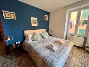 1 dormitorio con 1 cama con pared azul en RioRooms La Valletta Riomaggiore Center, en Riomaggiore