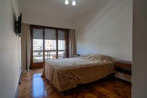 um quarto com uma cama e uma grande janela em Independencia & Balcarce em Mar del Plata