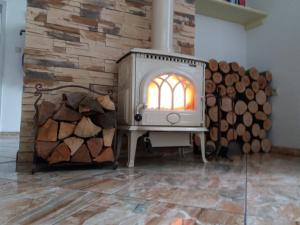 a wood burning stove in a room with logs at Chata Remata 879 in Handlová