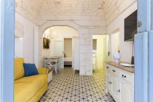 ein Wohnzimmer mit einem gelben Sofa und einem Tisch in der Unterkunft La Dimora del Tempo by Wonderful Italy in Ostuni