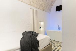 um quarto branco com uma banheira, uma cama e uma casa de banho em La Dimora del Tempo by Wonderful Italy em Ostuni