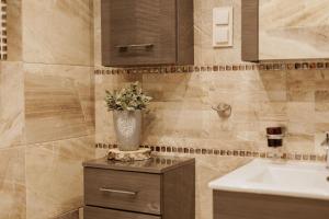 a bathroom with a sink and a vase with flowers at Taszówka in Taszów
