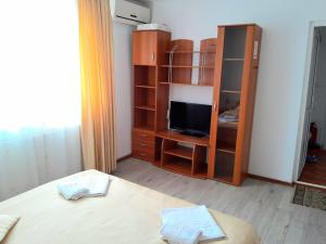 Habitación con cama, armario y TV. en Old Pensiunea Otopeni en Otopeni