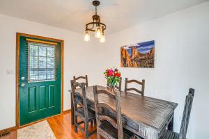 a dining room with a green door and a wooden table at Woodland Park Chalet with Deck, Grill and Mtn Views! in Woodland Park