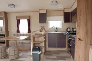 a small kitchen with a table and a sink at 2 Bed Caravan For Hire at Golden Sands in Rhyl in Rhyl