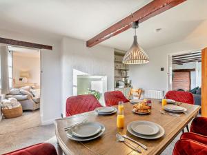 uma sala de jantar com uma mesa e cadeiras vermelhas em 5 Bed in Hoar Cross 94191 em Newborough