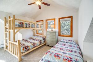 a bedroom with bunk beds and a ceiling fan at Woodland Park Chalet with Deck, Grill and Mtn Views! in Woodland Park