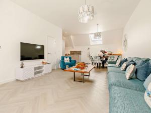 Una sala de estar con un sofá azul y un televisor. en 3 Bed in Newquay 90070, en Newquay
