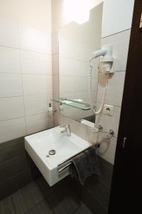uma casa de banho com um lavatório branco e um espelho. em Apartmán na Hlavnej ulici em Košice