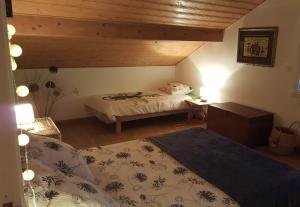 a bedroom with two beds and a wooden ceiling at Le Pti Clos 