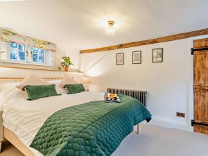 a bedroom with a large bed with a green blanket at 3 Bed in Kineton 93887 in Kineton