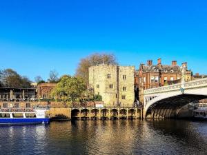 a bridge over a river in front of a castle at 3 Bed in Tollerton 93897 in Tollerton