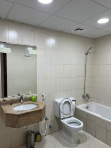 La salle de bains est pourvue de toilettes, d'un lavabo et d'une baignoire. dans l'établissement 30 R2 Single 1 Room in 3-bedroom apartment with separate washroom outside room with fantastic sea view 30 R2 غرفة مفردة في شقة مكونة من 3 غرف نوم مع حمام منفصل وغرفة خارجية بإطلالة رائعة على البحر, à Ajman