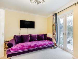 a purple couch in a living room with a tv at 3 Bed in Bewdley 93837 in Bewdley
