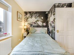 a bedroom with a bed with a floral wall at 3 Bed in Bewdley 93837 in Bewdley