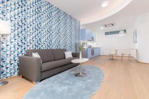 uma sala de estar com um sofá e uma parede azul e branca em limehome Graz - Argos by Zaha Hadid em Graz