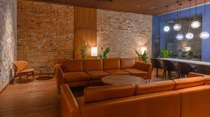 a lobby with a couch and a table and chairs at Radisson Hotel & Suites, Gdansk, Wyspa Spichrzów in Gdańsk