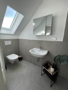 een badkamer met een wastafel, een toilet en een spiegel bij Frühlingsfrische Wohnung in Mönchengladbach