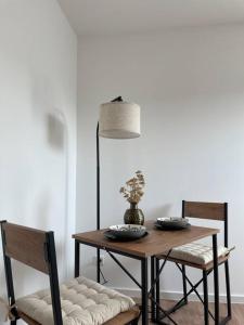 een eettafel met 2 stoelen en een tafel met bloemen bij Frühlingsfrische Wohnung in Mönchengladbach