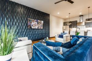 ein Wohnzimmer mit blauen Sofas und einer Wand in der Unterkunft Nashville Blues - Walk to Gulch - Rooftop Views of Downtown in Nashville