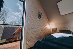 ein Schlafzimmer mit einem Bett und einem großen Fenster in der Unterkunft Domek Siodemka in Zakopane