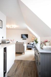 a white living room with a couch and a kitchen at Modern Apartment in the Heart of Oxford with Secure Underground Parking in Oxford