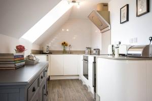 a kitchen with white cabinets and a skylight at Modern Apartment in the Heart of Oxford with Secure Underground Parking in Oxford