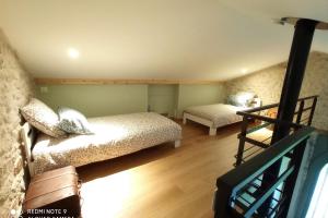 sala de estar con 2 camas y escalera en Gite avec mezzanine le Clos des Sœurs, en Bainville-aux-Saules