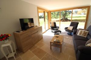 a living room with a couch and a tv at Gite avec mezzanine le Clos des Sœurs in Bainville-aux-Saules
