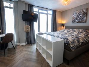 Schlafzimmer mit einem Bett und einem Schreibtisch mit einem TV in der Unterkunft Parade Elluf in Venlo