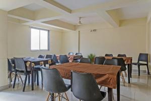 una sala de conferencias con mesas, sillas y una ventana en Collection O Hotel Galaxy Executive, en Kharadi