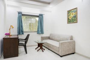 sala de estar con sofá, silla y mesa en Collection O Hotel Galaxy Executive, en Kharadi