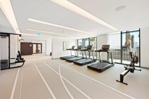 a gym with a row of treadmills and ellipticals at Silkhaus Marina View with Tower's Private Beach in Dubai