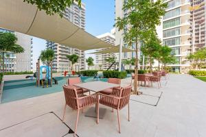 a patio with tables and chairs and a playground at Silkhaus Marina View with Tower's Private Beach in Dubai