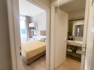 a bedroom with a bed and a sink and a mirror at Hotel Giappone - 2 Min Walk Duomo of Florence in Florence