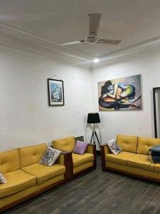uma sala de estar com dois sofás e um tecto em Élégante villa avec cour privée em Lomé