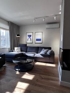 uma sala de estar com um sofá e uma televisão em Grand Apartment - Old Town & City Center em Gdansk