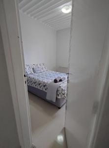 1 dormitorio con 1 cama en una habitación blanca en Quarto em apartamento em Cuiabá en Cuiabá