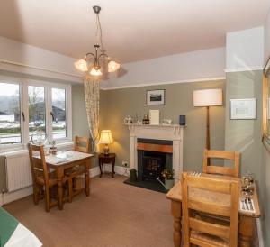 a living room with a table and a fireplace at Stockghyll Cottage in Bowness-on-Windermere